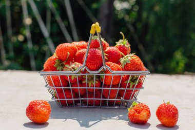 Mini alışveriş sepeti vintage arka plan taze kırmızı olgun çilek dolu