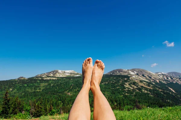 Feet up infront of the blue sky and mountains