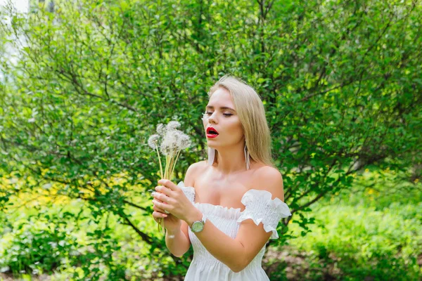 Mooie blonde vrouw waait op witte Blow Ball — Stockfoto