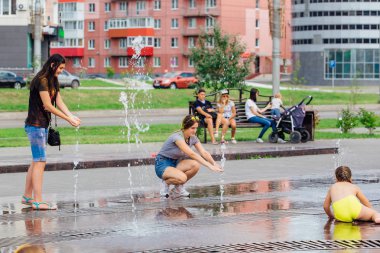 Novokuznetsk, Kemerovo Region, Rusya-04 Ağustos 2018: mutlu gençler bir şehir Çeşmesi suda sıçramak ve sıcak bir günde su serin akışları zevk.