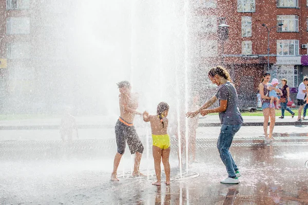俄罗斯克麦罗沃地区新库兹涅茨克-2018年8月4日: 快乐的孩子在城市喷泉的水中飞溅, 在炎热的天气里享受凉爽的水流. — 图库照片