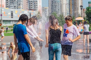 Novokuznetsk, Kemerovo Region, Rusya-04 Ağustos 2018: mutlu gençler bir şehir Çeşmesi suda sıçramak ve sıcak bir günde su serin akışları zevk.