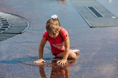 Novokuznetsk, Kemerovo Region, Rusya-04 Ağustos 2018: mutlu gençler bir şehir Çeşmesi suda sıçramak ve sıcak bir günde su serin akışları zevk.