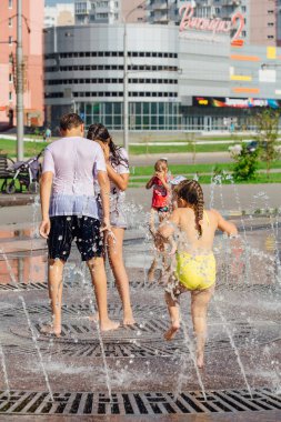 Novokuznetsk, Kemerovo Region, Rusya-04 Ağustos 2018: mutlu gençler bir şehir Çeşmesi suda sıçramak ve sıcak bir günde su serin akışları zevk.