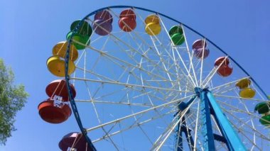 Mavi gökyüzü arka planında hareketli dönme dolap.