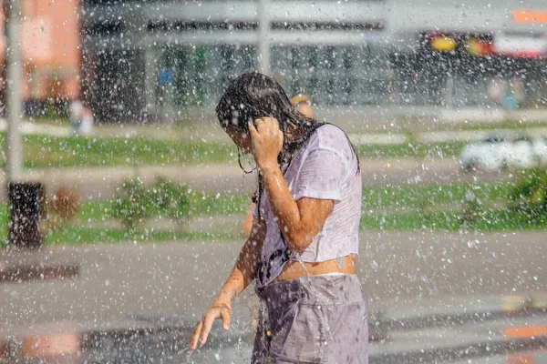 Nowokuźnieck, Kemerowo region, Rosja-04 sierpnia 2018: Happy nastolatków rozpryskiwania w wodzie fontanna miasta i korzystających z fajnych strumieni wody w gorący dzień. — Zdjęcie stockowe