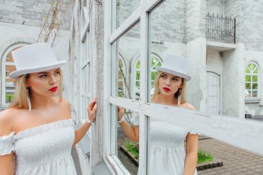 Beyaz silindir şapka seksi modern gelin ayna pencere izliyor