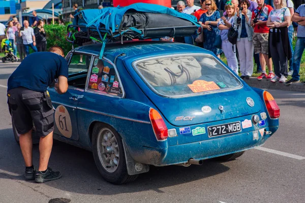 Nowokuźnieck, Rosja-14 czerwca 2019: The 7th Peking do Paris Motor Challenge 2019. MGB gt 1972 pozostawiając miasto i przechodząc do kolejnego etapu rajdu. — Zdjęcie stockowe