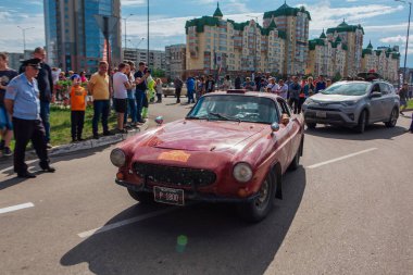 Novokuznetsk, Rusya-14 Haziran 2019: 7. Volvo P1800s 1968 şehirden ayrılıyor ve ralli başka bir aşamaya gidiyor.