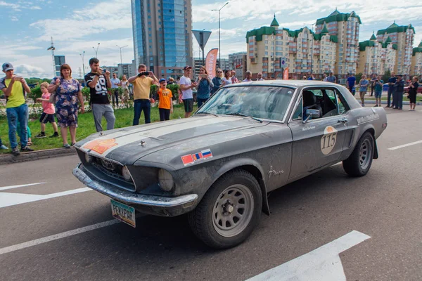 Novokuznetsk, Rusia-14 de junio de 2019: El 7º Desafío del Automóvil de Pekín a París 2019. Ford Mustang 1968 dejando la ciudad y yendo a otra etapa de rally . — Foto de Stock