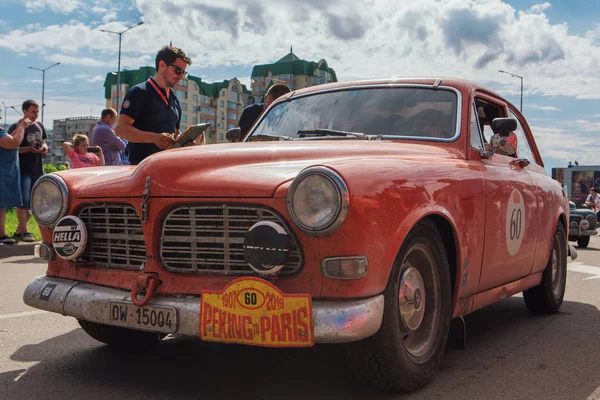 Novokuznetsk, Rusia-14 de junio de 2019: El 7º Desafío del Automóvil de Pekín a París 2019. Volvo 121 1969 saliendo de la ciudad y yendo a otra etapa del rally . — Foto de Stock