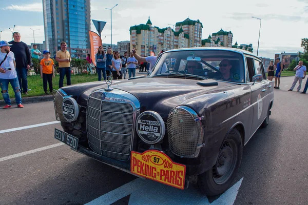 Novokuznetsk, Rusia-14 de junio de 2019: El 7º Desafío del Automóvil de Pekín a París 2019. Mercedes Benz 230S Fintail 1966 saliendo de la ciudad y yendo a otra etapa del rally . — Foto de Stock