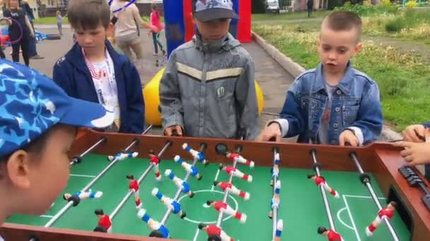Novokuznetsk, Rusia - 09 de junio de 2019: Niños jugando a kicker game — Vídeos de Stock