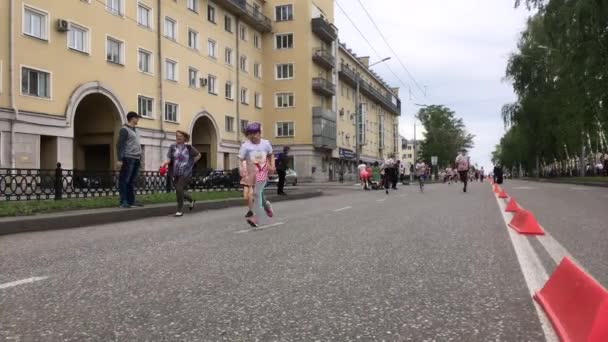 Novokuznetsk, Ryssland - 09 juni 2019: "High Five" - det 5:e massidrottsloppet bland människor i olika åldrar. Barnen springer i masslopp — Stockvideo