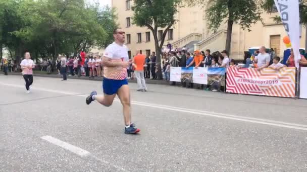 Novokuznetsk, Rusia - 09 de junio de 2019: "High Five", la quinta carrera deportiva masiva entre personas de diferentes edades. La gente está corriendo en una carrera masiva — Vídeos de Stock