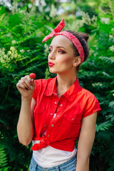 Belle jeune fille pin up avec maquillage lumineux manger fraise naturelle fraîche . — Photo