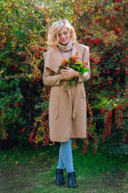 Sonbahar parkta sonraki karamuk Bush ayakta güzel zarif kadın