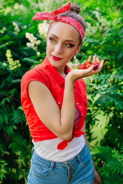 Schöne junge Pin-up-Mädchen mit hellem Make-up und frische natürliche Erdbeere. — Stockfoto