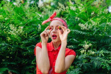 Parlak gözlerine yakın taze doğal çilek tutarak makyaj ile kız kadar güzel genç pin.