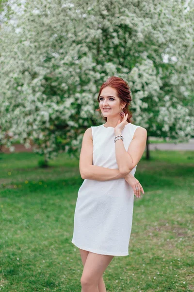 Charmante vrouw het dragen van mooie witte jurk onder de appelboom — Stockfoto