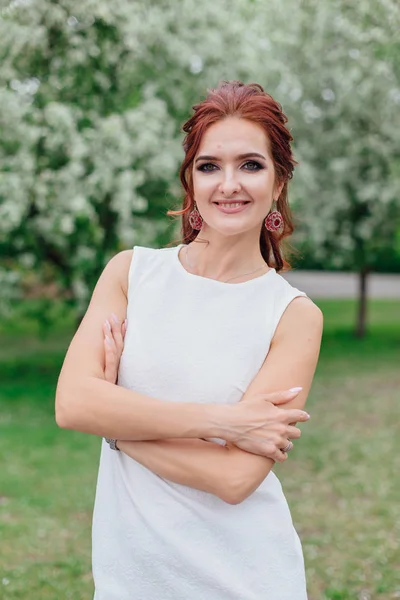 Mujer encantadora vistiendo hermoso vestido blanco bajo el manzano — Foto de Stock