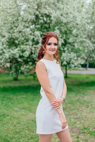 Mujer encantadora vistiendo hermoso vestido blanco bajo el manzano — Foto de Stock
