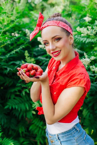 Mooie jonge pin-up girl met lichte make-up en verse natuurlijke aardbei. — Stockfoto