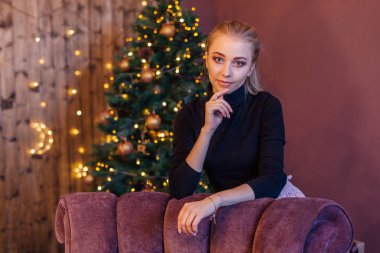 Güzel genç kadın uzun saçlı nex Noel ağacına ayakta.