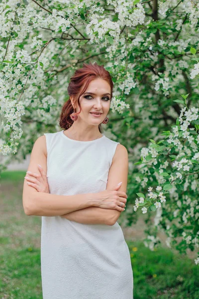 Mujer encantadora vistiendo hermoso vestido blanco bajo el manzano — Foto de Stock