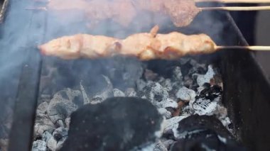 Şef Barbekü hazırlar. İştah açıcı lezzetli kızarmış parça et şiş üzerinde açık bir büyük ızgara kavrulmuş