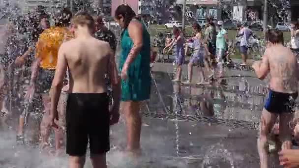 Novokuznetsk, Region Kemerowo, Russland - 28. Juni 2019: fröhliche Teenager planschen im Wasser eines Stadtbrunnens und genießen die kühlen Wasserströme an einem heißen Tag. — Stockvideo