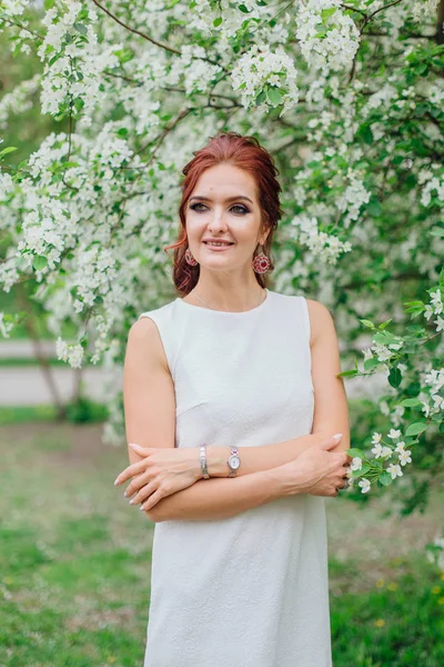 Charmante Frau in schönem weißen Kleid unter dem Apfelbaum — Stockfoto