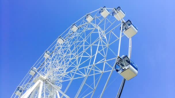 Roue ferris en mouvement sur le fond bleu ciel . — Video