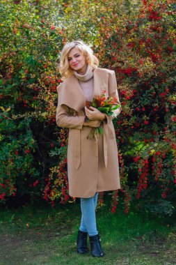 Sonbahar parkta sonraki karamuk Bush ayakta güzel zarif kadın