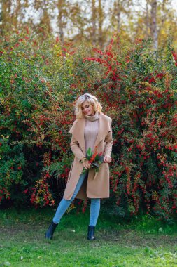 Sonbahar parkta sonraki karamuk Bush ayakta güzel zarif kadın