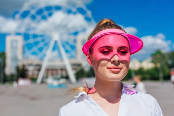 Porträtt av en känslomässig flicka i en rosa mössa visir och skyddshandskar för rullskridskor och skateboard. — Stockfoto