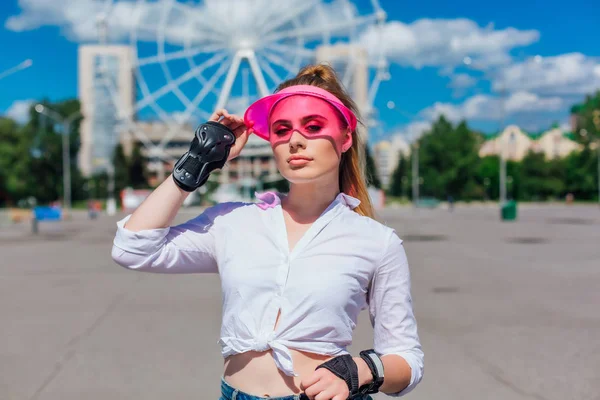 Портрет эмоциональной девушки в розовом колпаке и защитные перчатки для роликов и скейтбординга . — стоковое фото