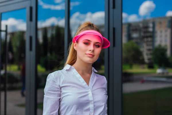 Potret seorang gadis emosional dengan topi merah muda dan sarung tangan pelindung untuk rollerblades dan skateboard . — Stok Foto