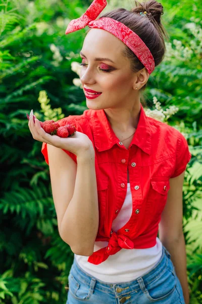 Schöne junge Pin-up-Mädchen mit hellem Make-up und frische natürliche Erdbeere. — Stockfoto