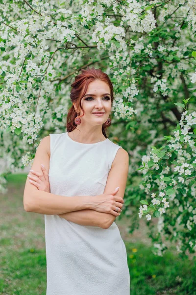 Charmante Frau in schönem weißen Kleid unter dem Apfelbaum — Stockfoto