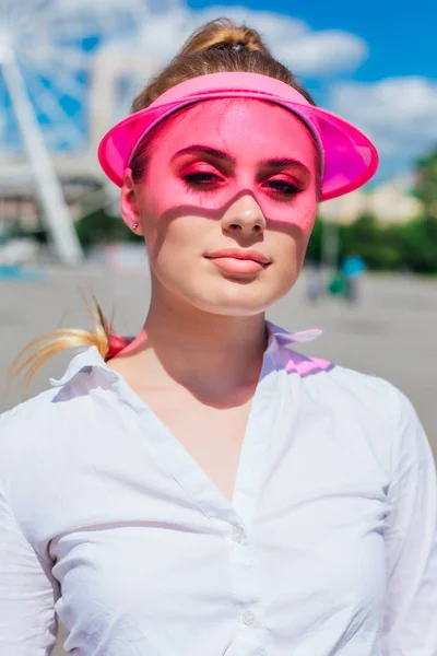 Retrato de una chica emocional con una visera de gorra rosa y guantes protectores para patines y skateboarding . — Foto de Stock