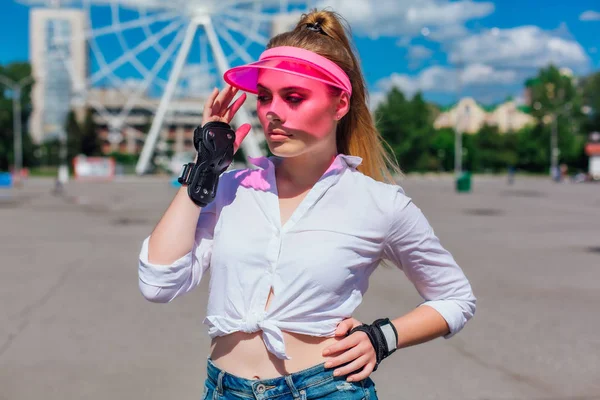 Πορτραίτο ενός συναισθηματικού κοριτσιού σε ένα ροζ καπάκι και προστατευτικά γάντια για πατίνια και σκέιτμπορντ. — Φωτογραφία Αρχείου