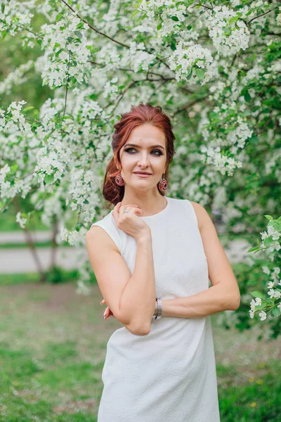 Urocza kobieta ubrana w piękną białą sukienkę pod jabłkiem — Zdjęcie stockowe