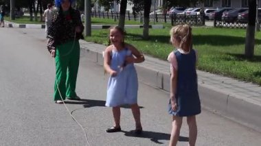 Novokuznetsk, Rusya - 07 Temmuz 2019: Okul çağında ki iki küçük kız dışarıda ip atlamayla oynuyor