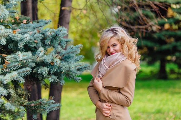 Mooie elegante vrouw staande onder de dennenboom in Autumn Park — Stockfoto