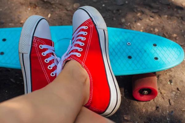 Primo piano di piedi e penny skate board blu con ruote rosa . — Foto Stock