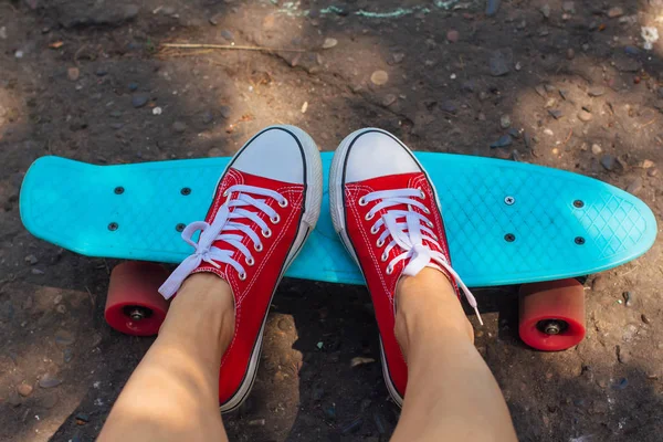 Primo piano di piedi e penny skate board blu con ruote rosa . — Foto Stock