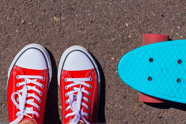 Gros plan des pieds et planche à roulettes bleu penny avec roues roses . — Photo