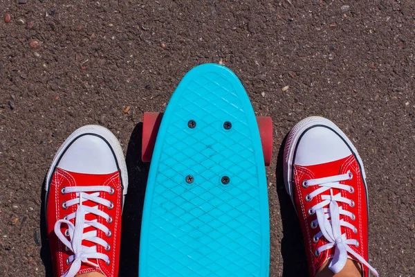 Primo piano di piedi e penny skate board blu con ruote rosa . — Foto Stock