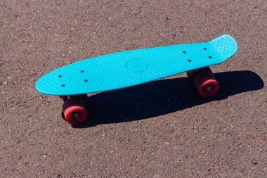 Yolda pembe tekerlekler ile mavi kuruş kurulu.